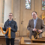 Pfarrer Peter Wohs und Küster Andreas Ataman beim Absperren der Kirchenbänke