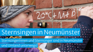 Sternsingeraktion in Neumünster – Sternsingerin schreibt Segensspruch mit Kreide an die Hauswand.